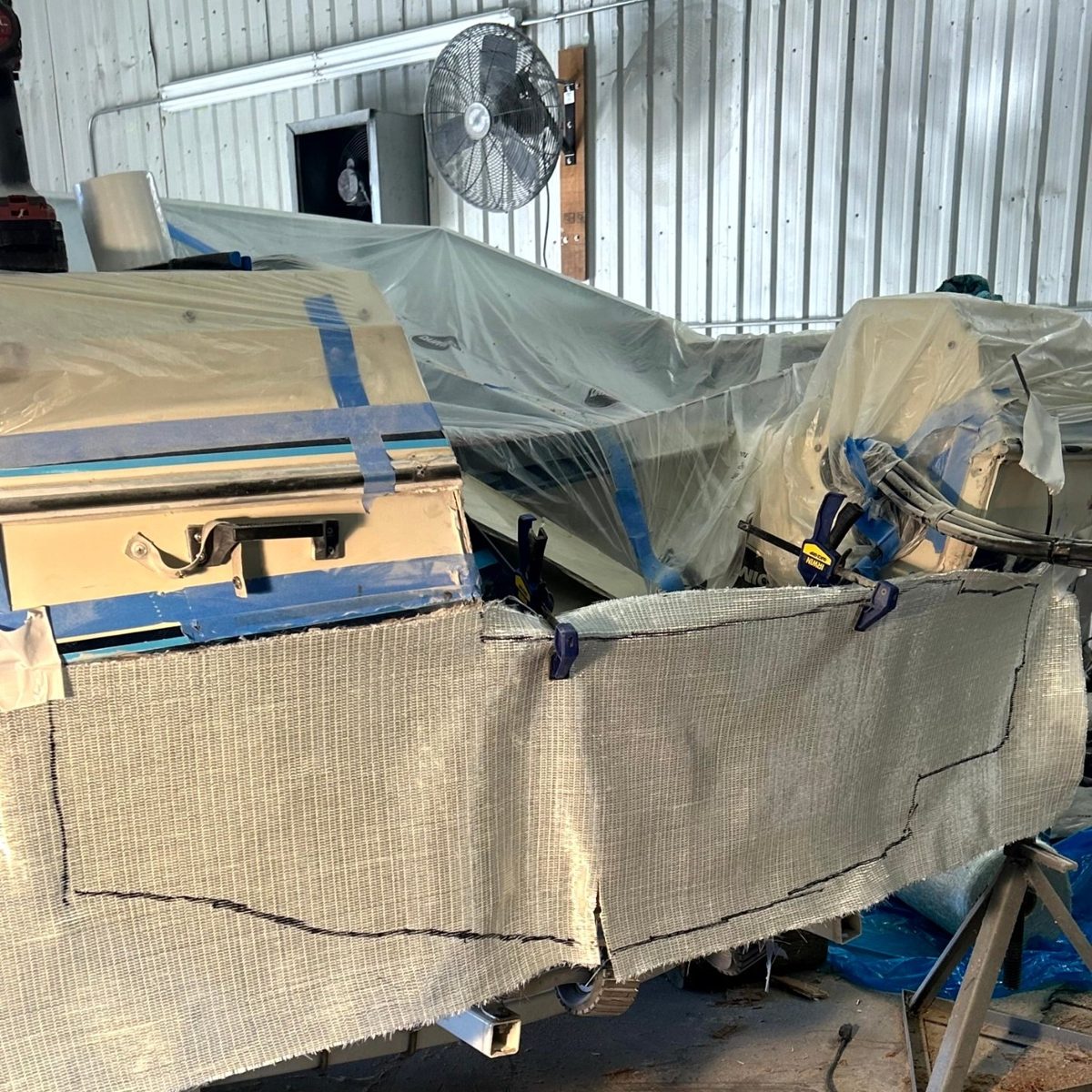 New fiberglass cloth cut to shape and clamped in place, ready to lay up.