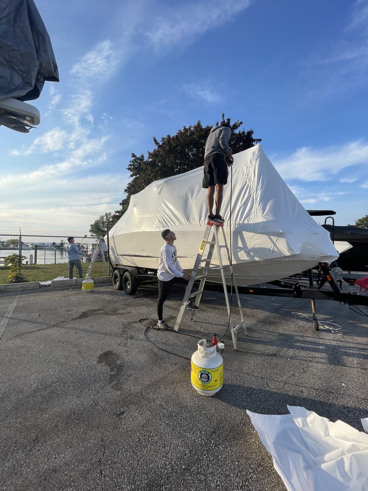 Toronto Yacht Club crew shrink wrapping a boat on a trailer