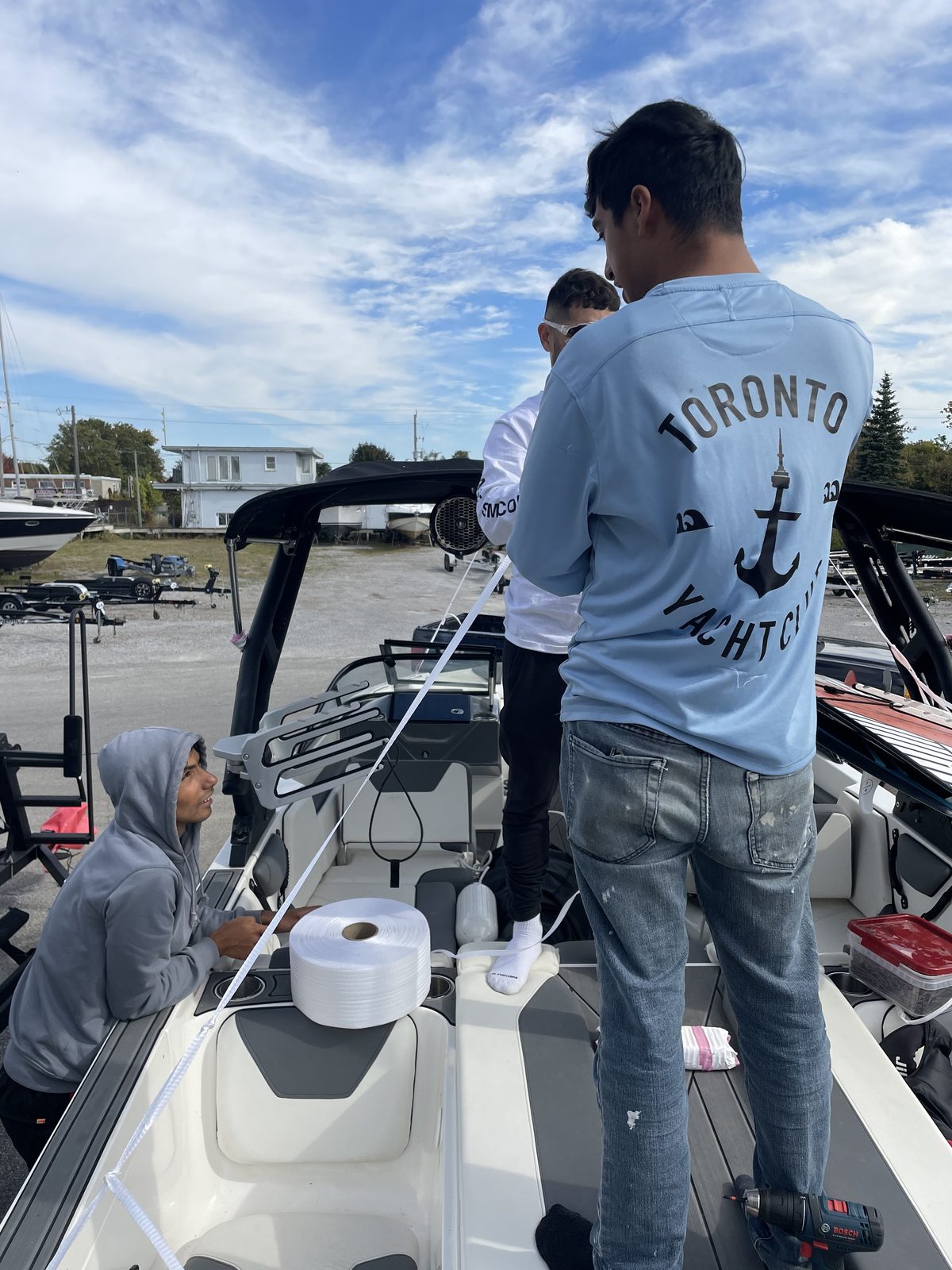 Toronto Yacht Club crew running strapping across a boat before wrapping